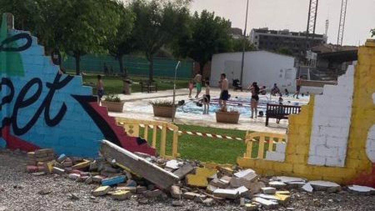 Part del mur de les piscines del poliesportiu de Balaguer, enderrocat i precintat.