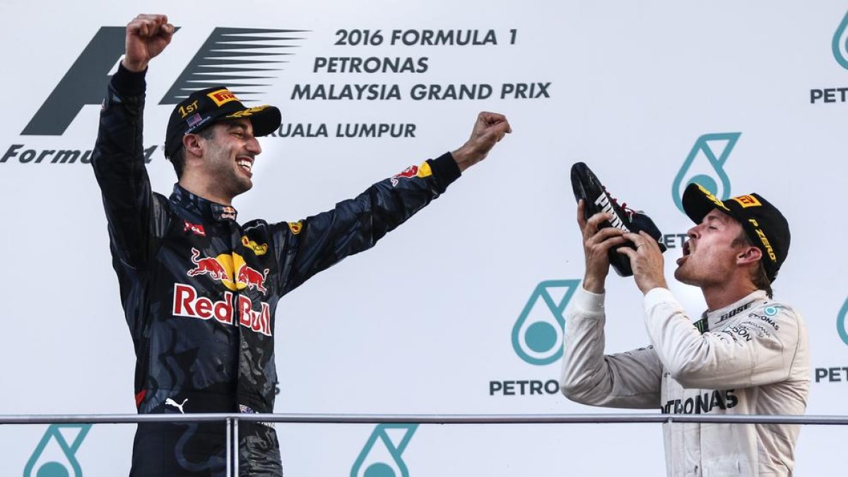 Daniel Ricciardo celebra la victòria a Sepang al costat de Nico Rosberg, eufòric després d’incrementar l’avantatge al capdavant del Mundial.