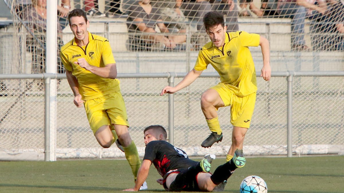 Dos jugadors de l’EFAC en superen un del Reus en una jugada del partit d’ahir.