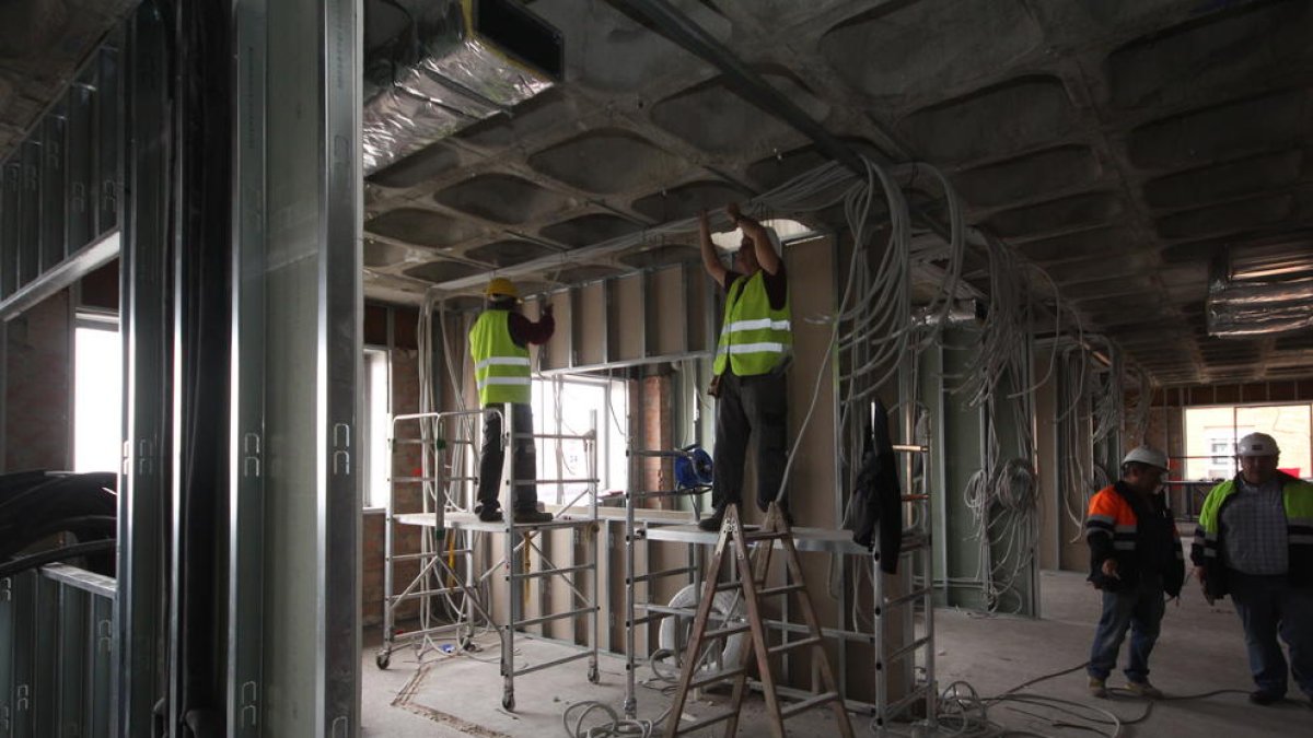 Varios operarios trabajaban ayer en las nuevas habitaciones de la UCI del Arnau de Vilanova. 