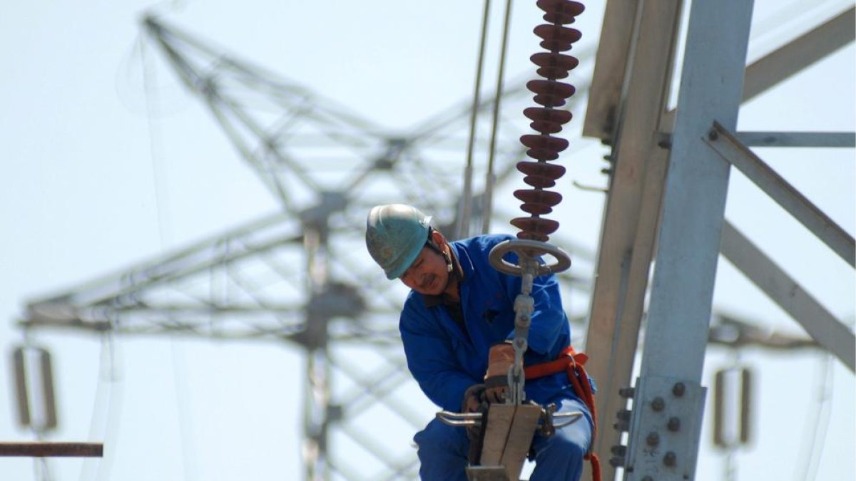 Un treballador en una línia elèctrica