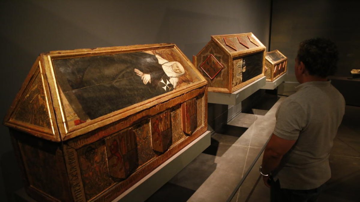 Un visitante contemplando las tres cajas sepulcrales del Museu de Lleida reclamadas por Aragón.