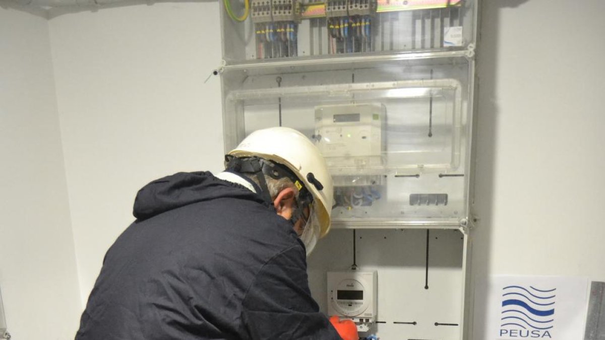 Un operari de Peusa, l’elèctrica de l’Alt Urgell, instal·lant un comptador intel·ligent.