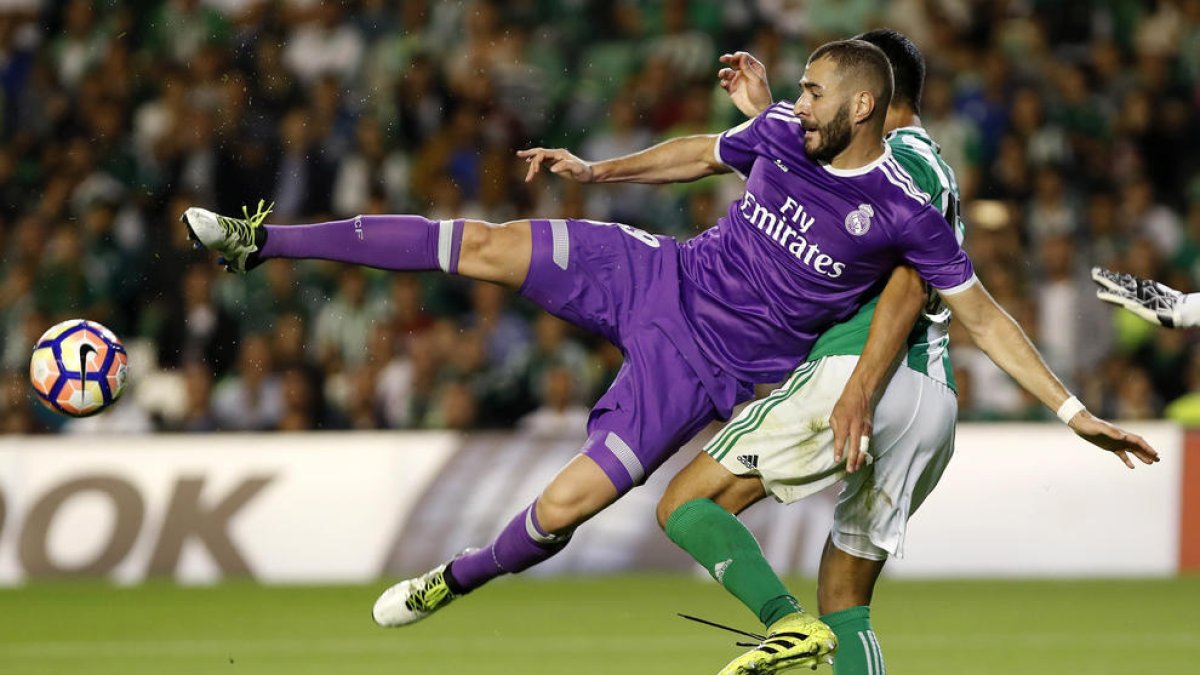 Karim Benzema intenta rematar davant de l’argelià Aissa Mandi, defensa del Betis.