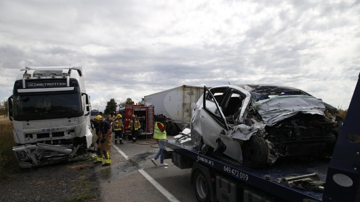 El cotxe de la víctima, pujat a la grua, i en segon terme el camió implicat en l'accident.