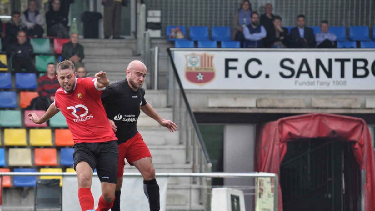 Un jugador de l’Alpicat, amb la samarreta negra, pressiona un futbolista del Santboià.