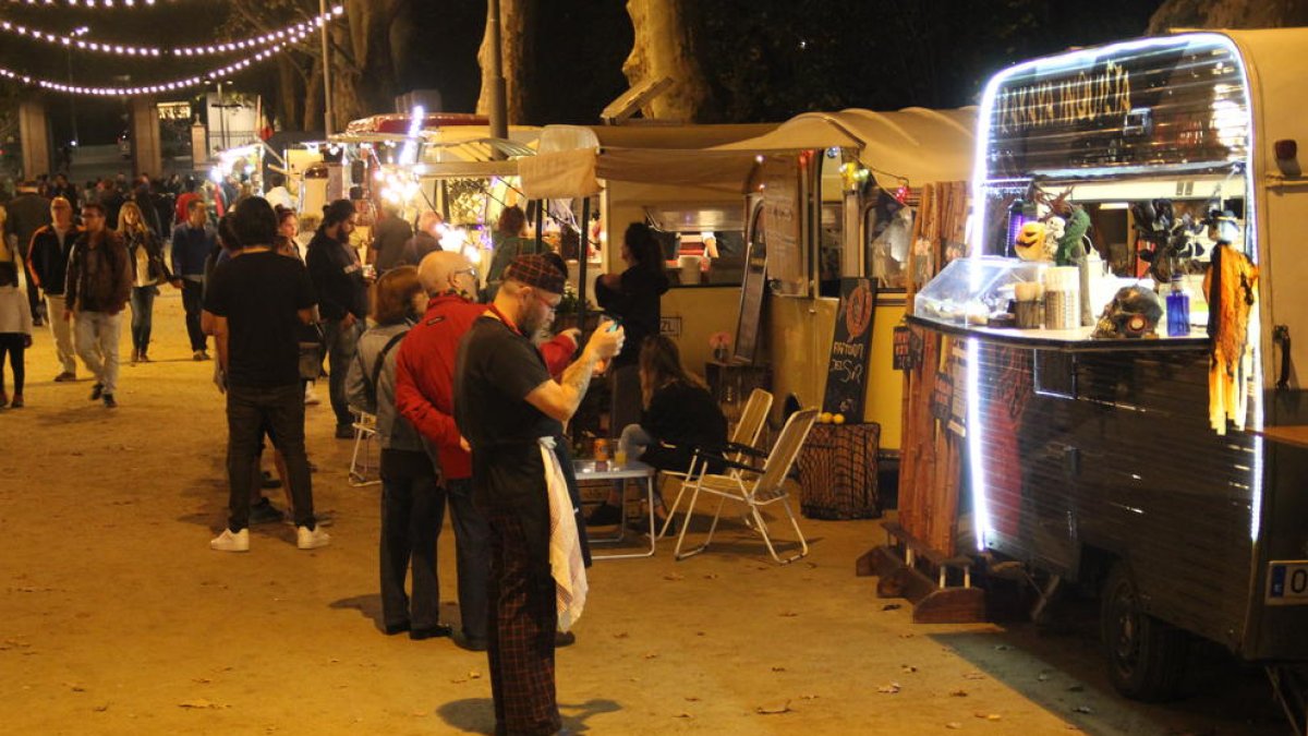 Imatge presa ahir a la nit de les caravanes de cuina i dels primers visitants als Camps Elisis.