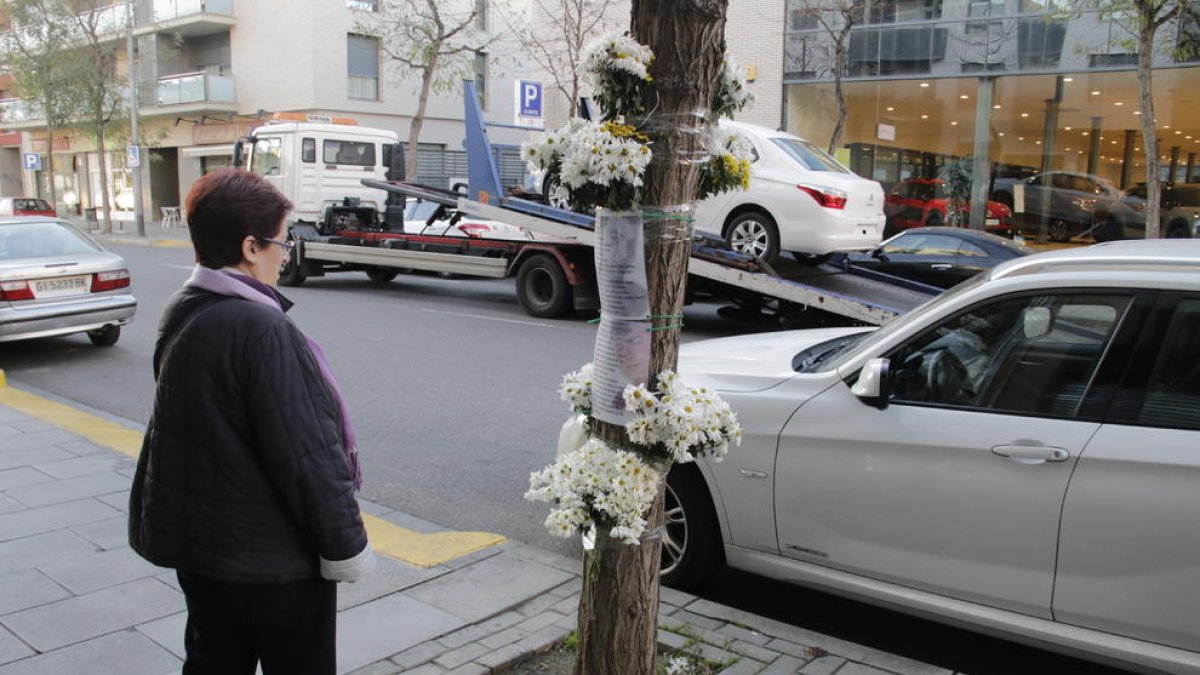 Ramos y un texto con fotos de Isaac de fondo, ayer a la salida del parking donde tuvo lugar el asesinato.