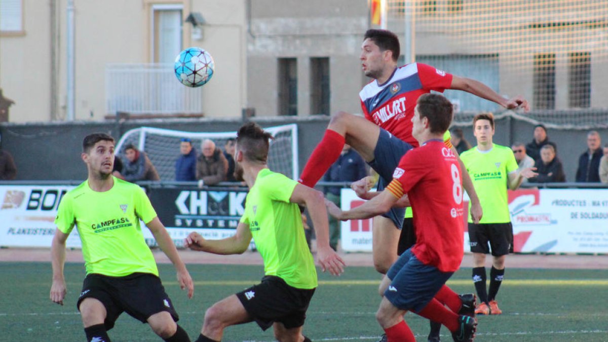 Pau Solanes rebutja la pilota davant de l’atenta mirada de dos jugadors del Viladecans.