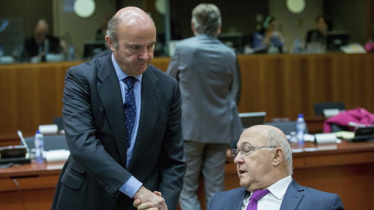 Luis de Guindos saluda el ministre francès de Finances, Michel Sapin, ahir a Brussel·les.