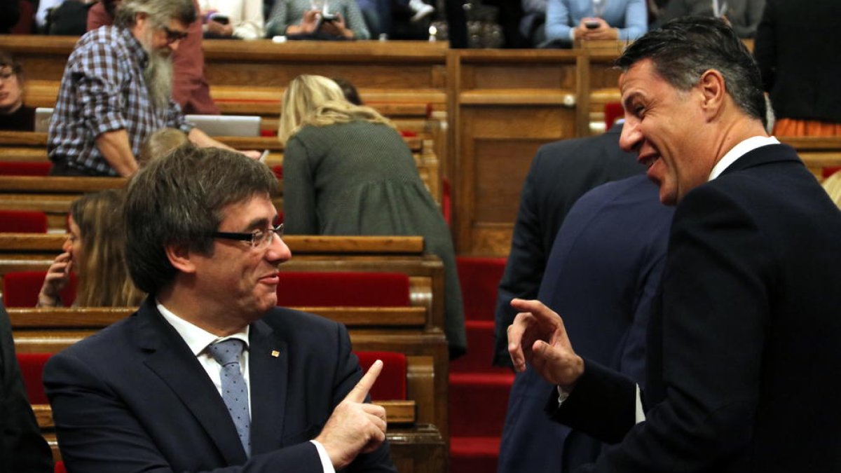 Puigemont bromea con el líder del PP catalán, Xavier García Albiol, ayer en el Parlament.