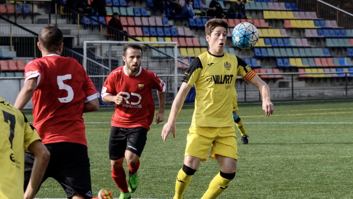 El capitán del Balaguer y autor del único gol de ayer, Isaac, controla el balón con el pecho ante la presión de dos jugadores del Santboià.