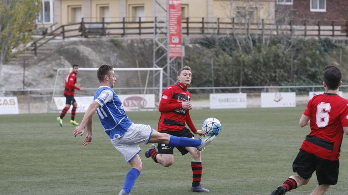 Un futbolista del Morell intenta controlar davant de l’oposició d’un jugador de l’EFAC Almacelles.