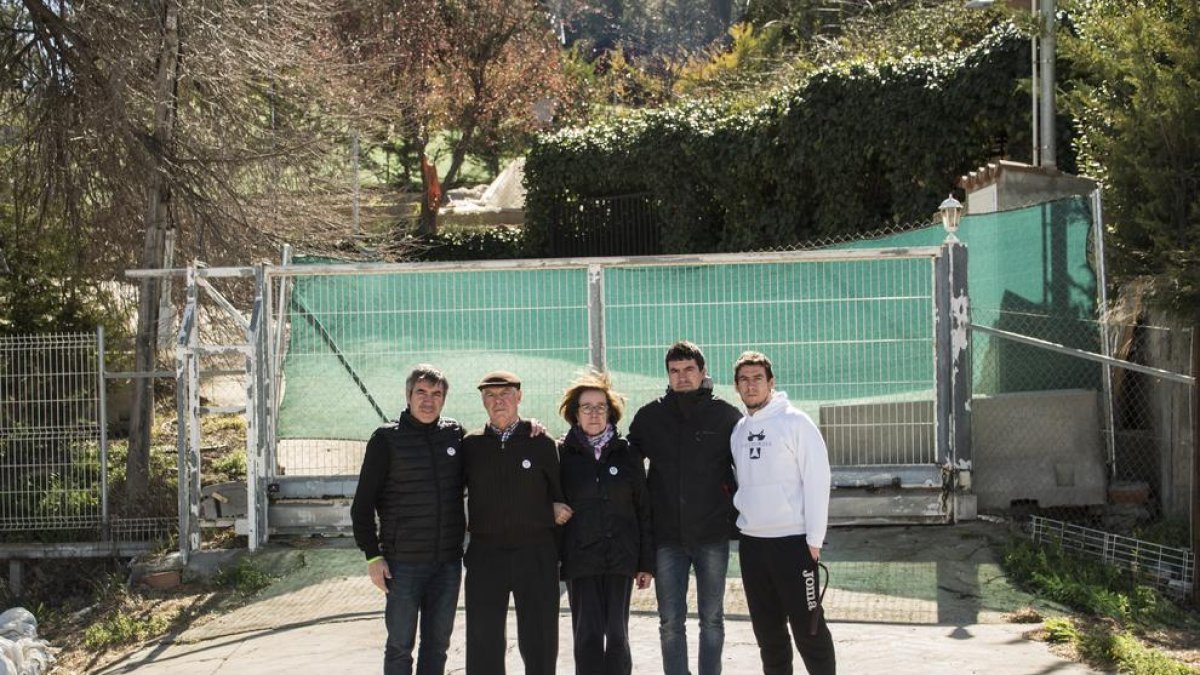 La familia Pifarré, ante la puerta que cierra el acceso a la granja.