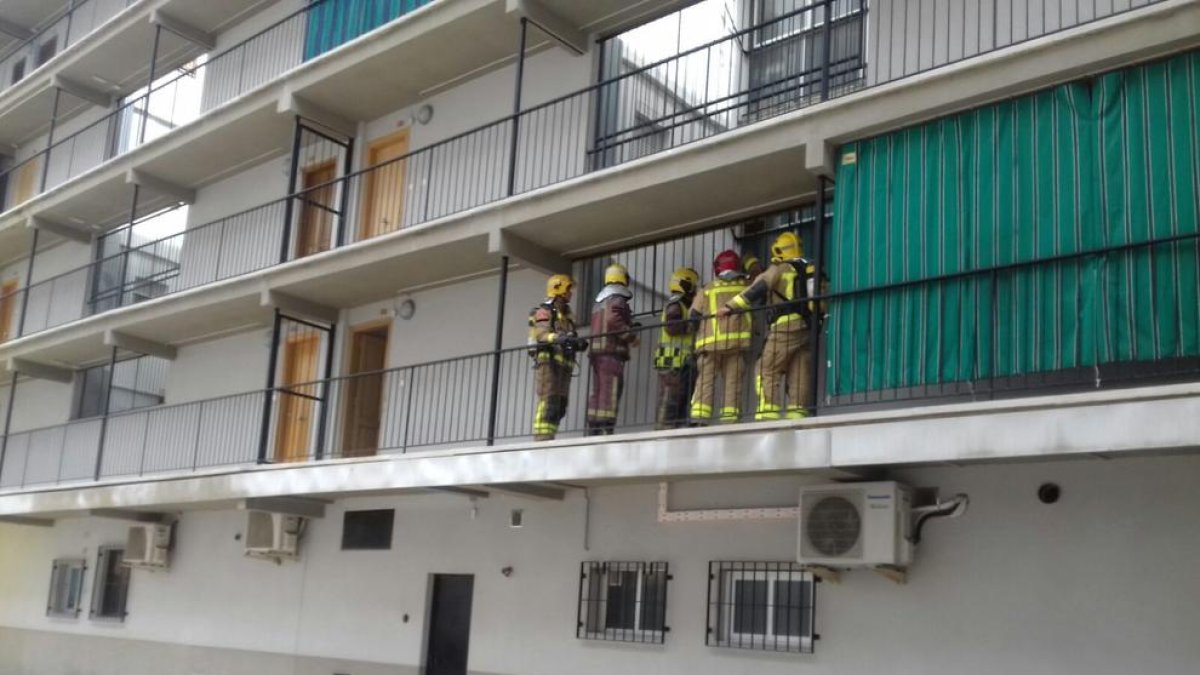 Bomberos en el balcón de la vivienda.