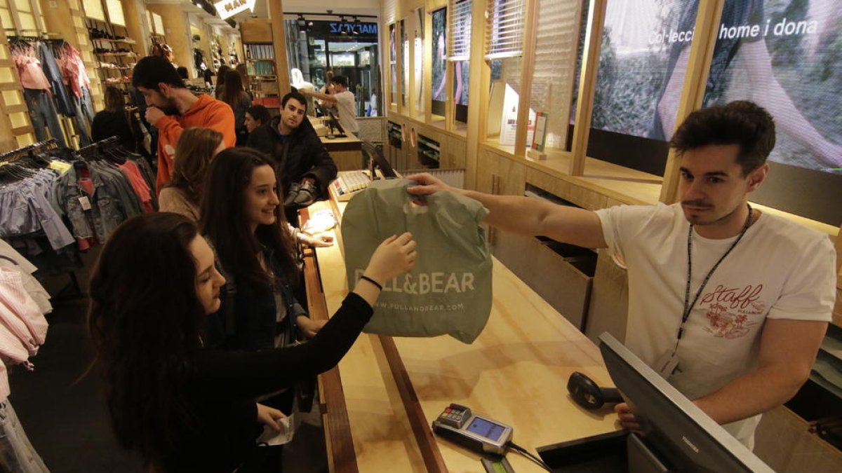 Un establecimiento del Eix Comercial entregando ayer una bolsa a una clienta aún de forma gratuita.