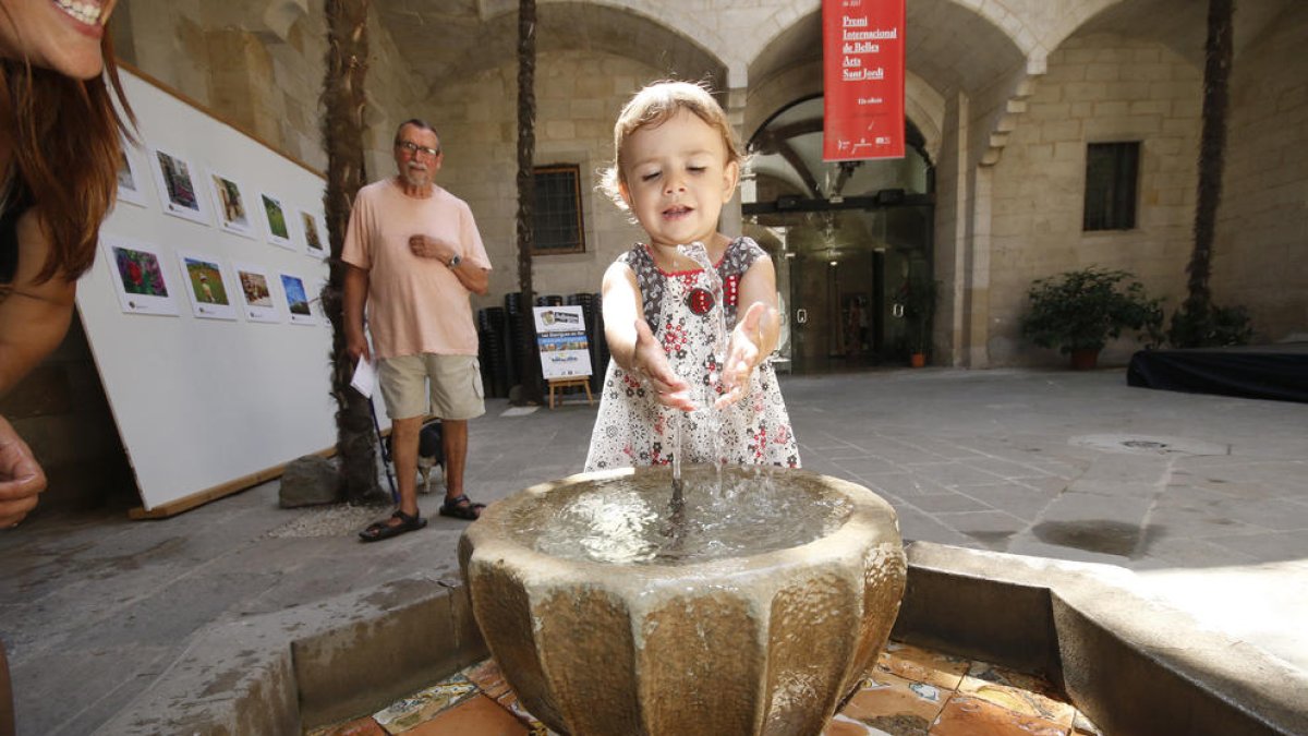Una niña se refrescaba ayer de las altas temperaturas en Lleida en la fuente del IEI.