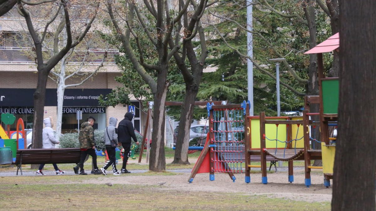 Un grup de joves passeja per un parc de Balàfia, que avui quedarà tancat.
