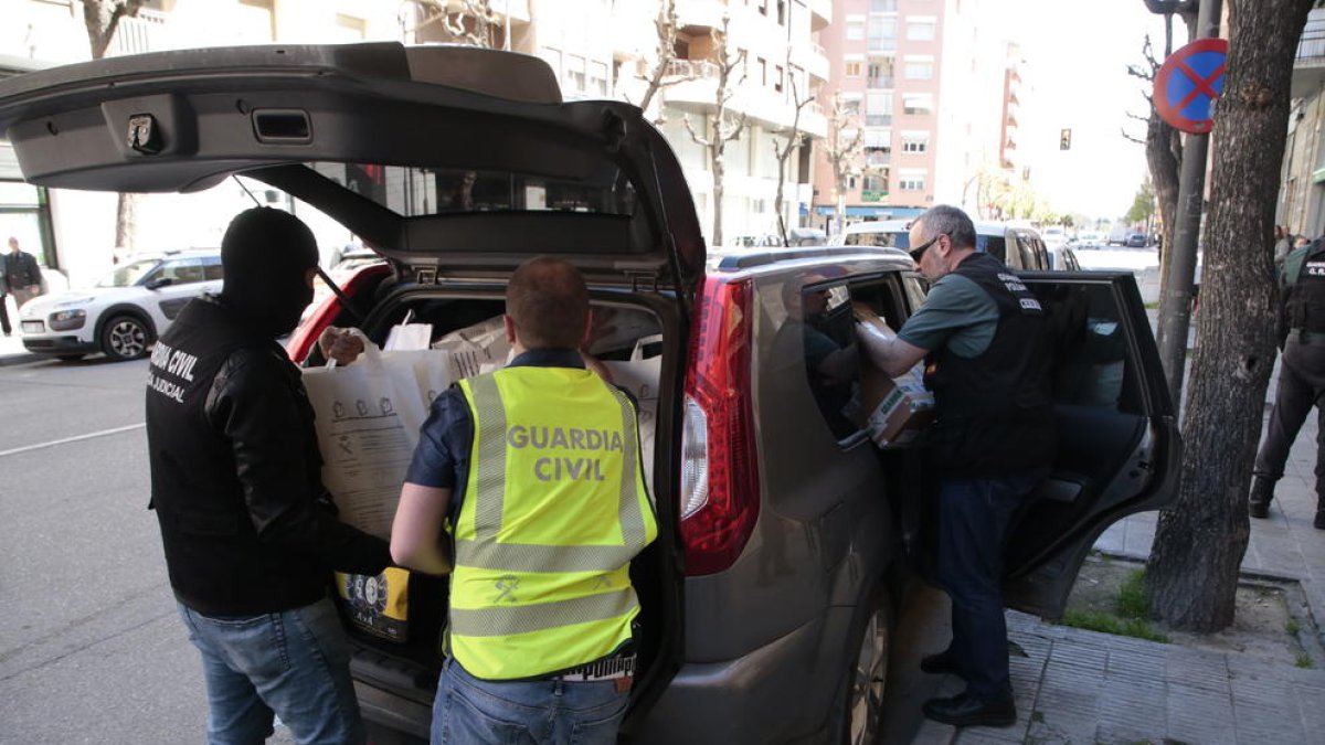 Agentes cargan material decomisado en el piso de Cappont donde vivían tres de los detenidos.