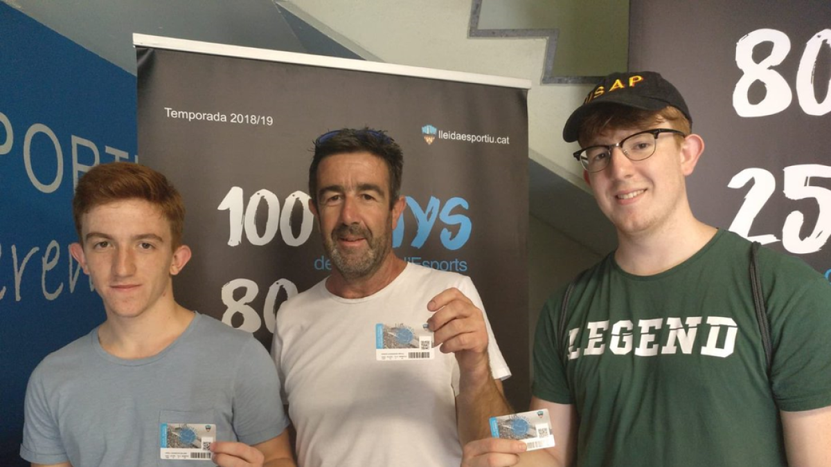 Tres abonados del Lleida Esportiu muestran orgullosos ayer su carnet.