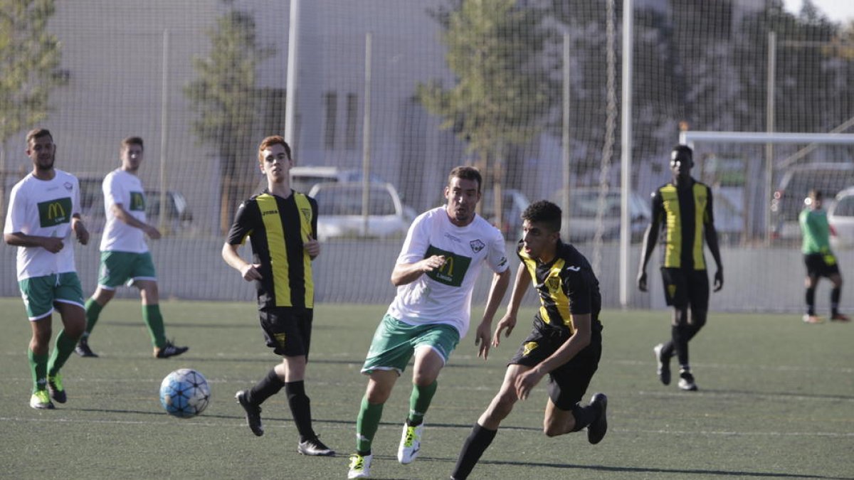 Jugadores del equipo local y del visitante disputándose el balón.