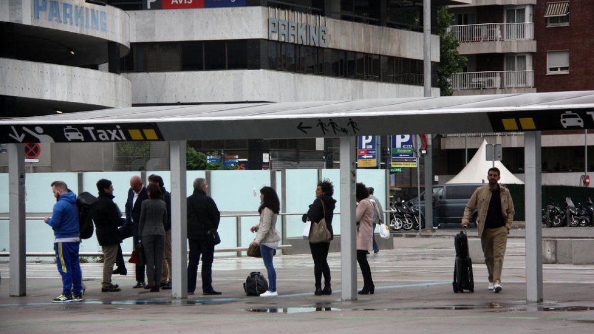 Un grupo de personas esperando un taxi en la estación de Sants.