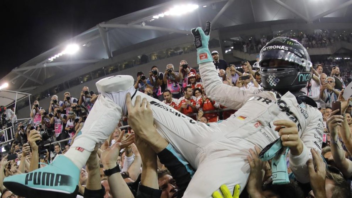 Nico Rosberg es manteado en el circuito Yas Marina después de lograr el título de campeón del mundo.
