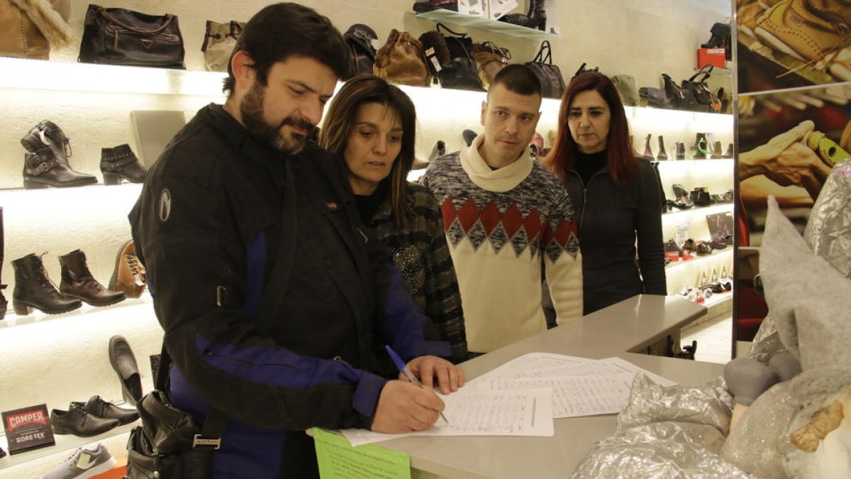 Clientes firmando ayer en la campaña promovida por los comerciantes. 