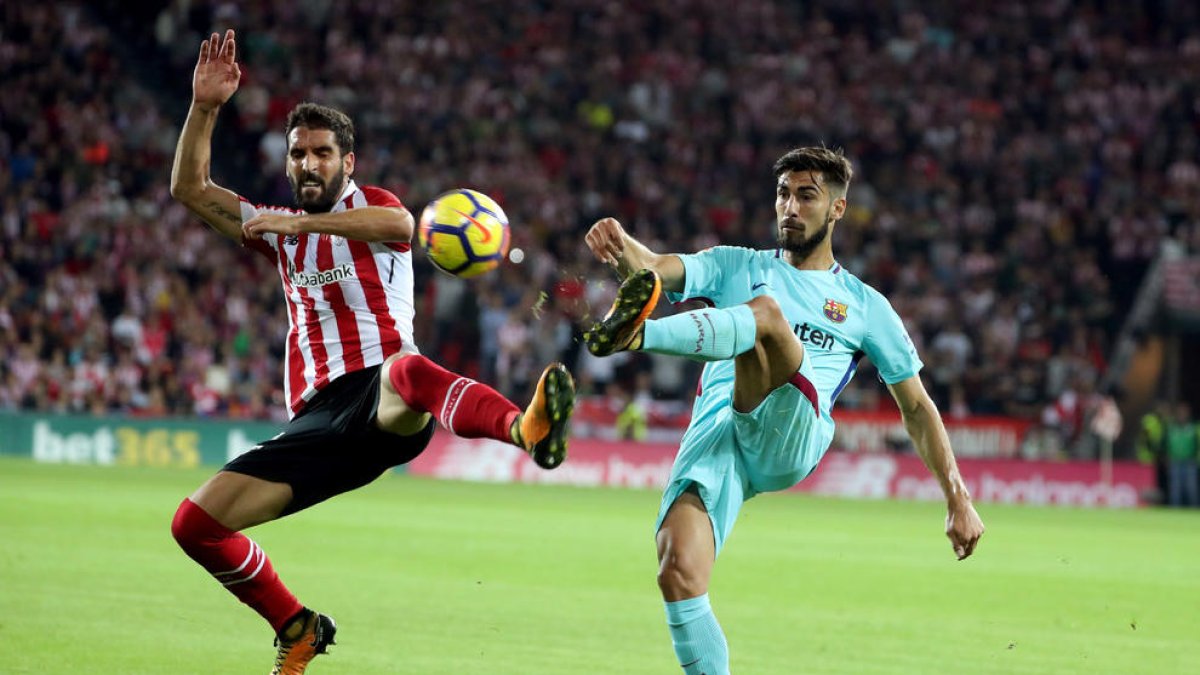 André Gomes intenta dar un pase ante Raúl García.