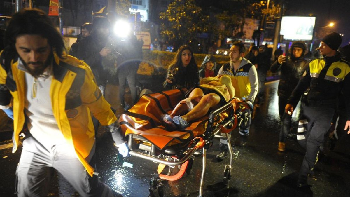 Els serveis mèdics traslladen en llitera a una ambulància un ferit en l’atac contra el popular club nocturn Reina, a Istanbul.