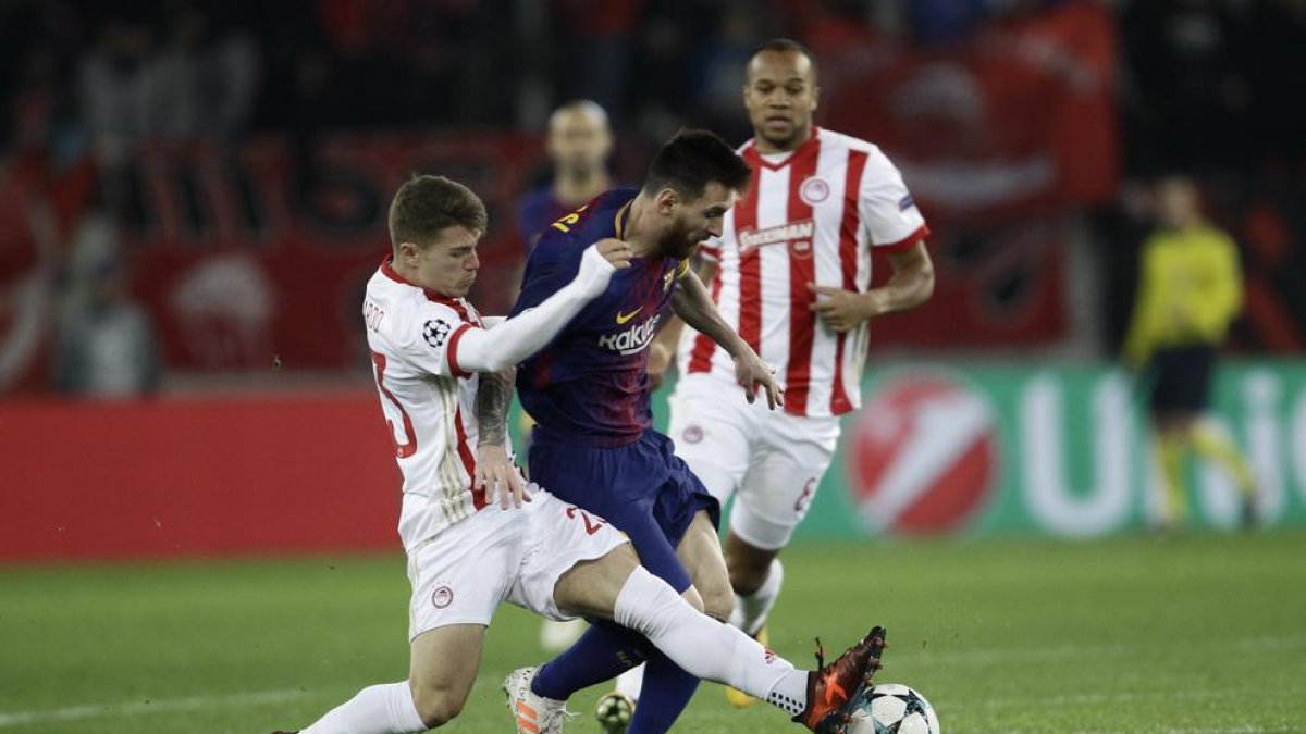 Messi intenta desbordar a dos jugadores del Olympiacos.