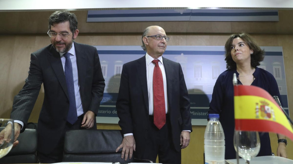 El ministre d'Hisenda, Cristóbal Montoro, la vicepresidenta del Govern, Soraya Sáenz de Santamaría, i el secretari d'Estat de Pressupostos, Alberto Nadal, a l'inici de la reunió del Consell de Política Fiscal i Financera.