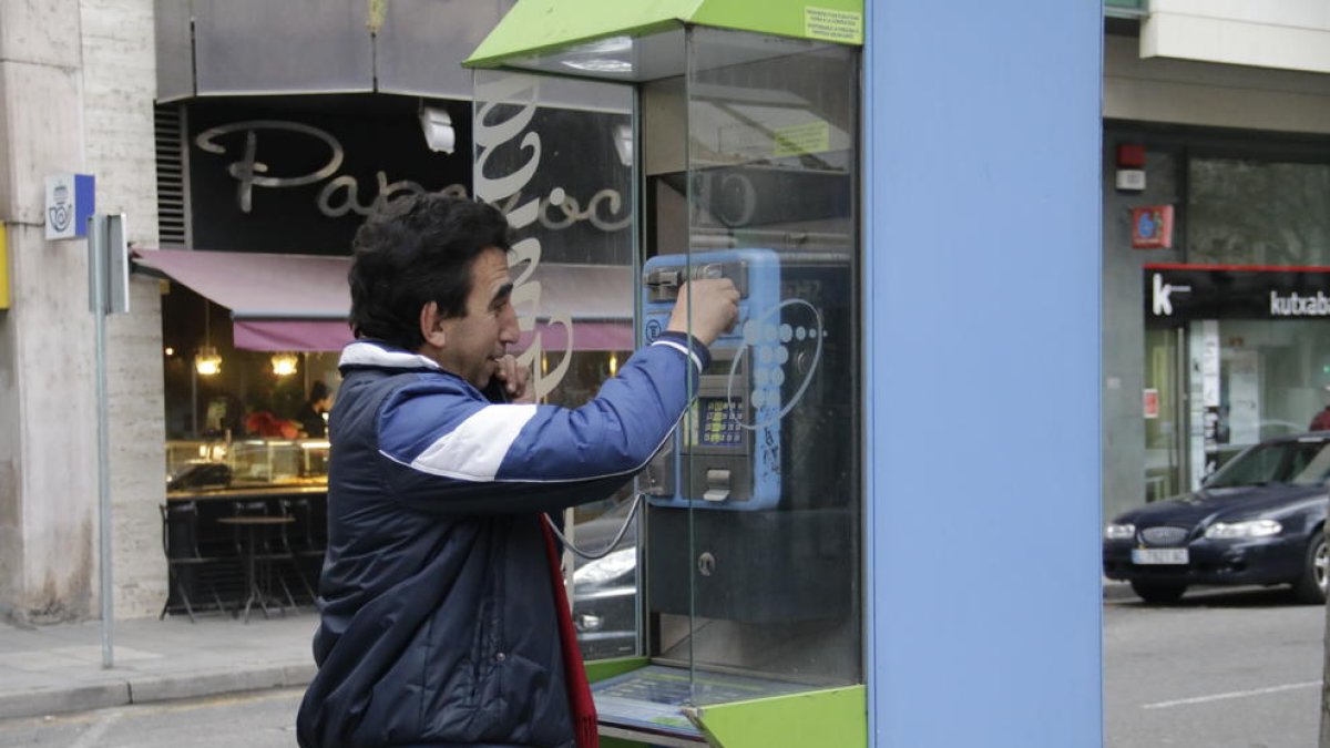 Un usuario en una cabina telefónica ubicada en la Rambla Ferran.