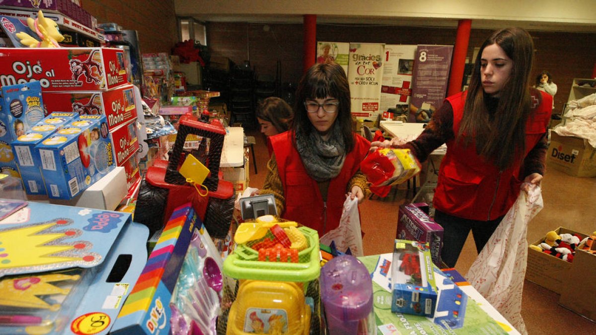 Voluntarias preparan, ayer, los lotes de regalo en las instalaciones de la institución en Lleida ciudad.