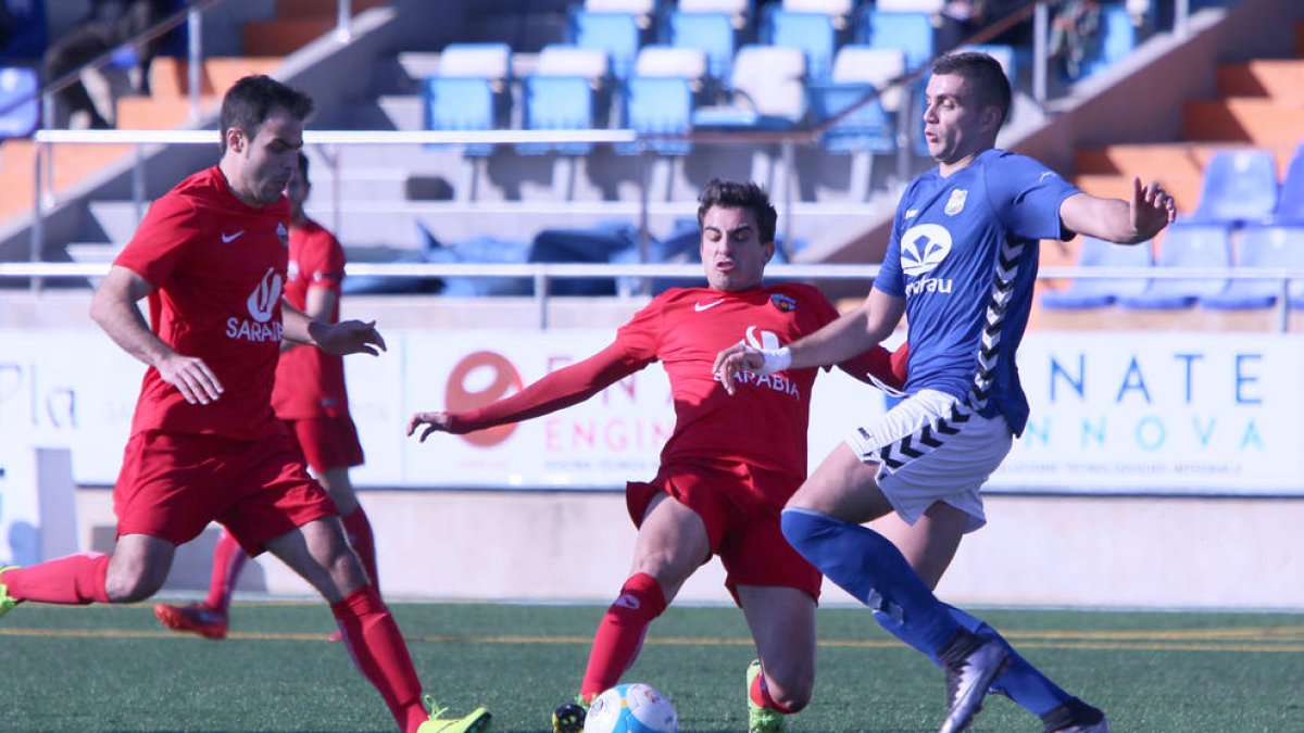 Dos futbolistas del Alpicat luchan por el balón ante un jugador de la Rapitenca, en una acción del partido de ayer.