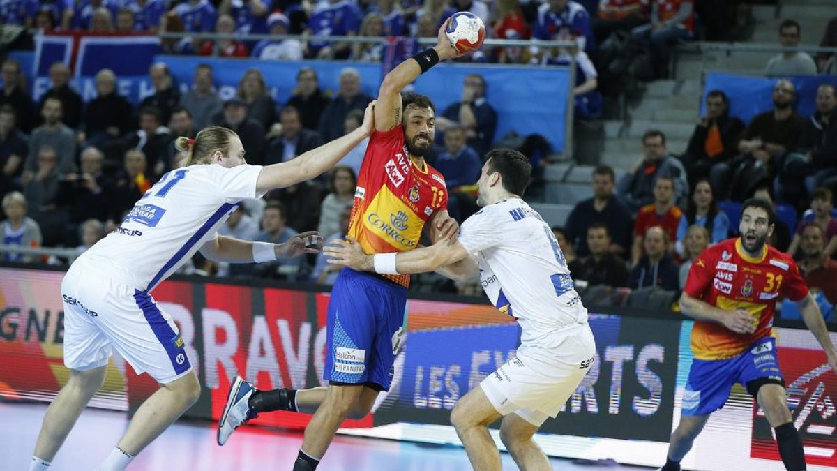 El central español  Daniel Sarmiento intenta lanzar entre dos jugadores islandeses.