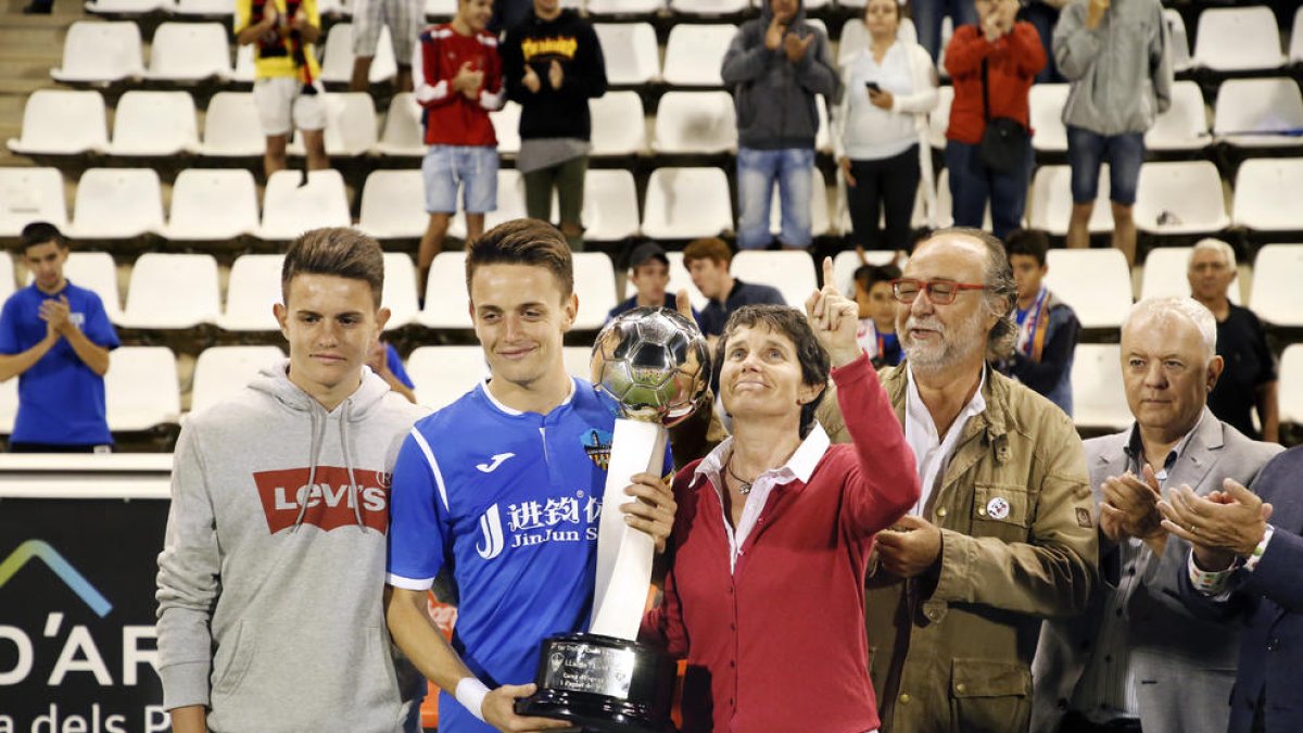 Toni y Joan Vicente, los hijos de Emili, posan junto a su madre, Antònia Armengol, que entregó el trofeo de campeón a Joan, como capitan del Lleida.