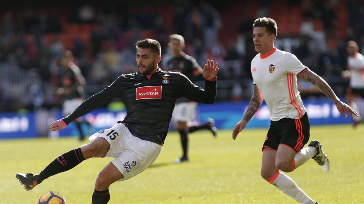 David López, golejador ahir, controla la pilota davant de Santi Mina. 