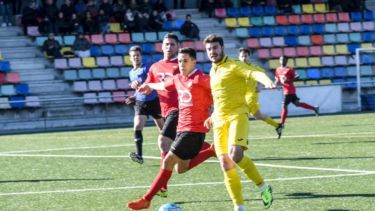 Un jugador de l’EFAC Almacelles controla la pilota davant de la pressió d’un jugador del Santboià.