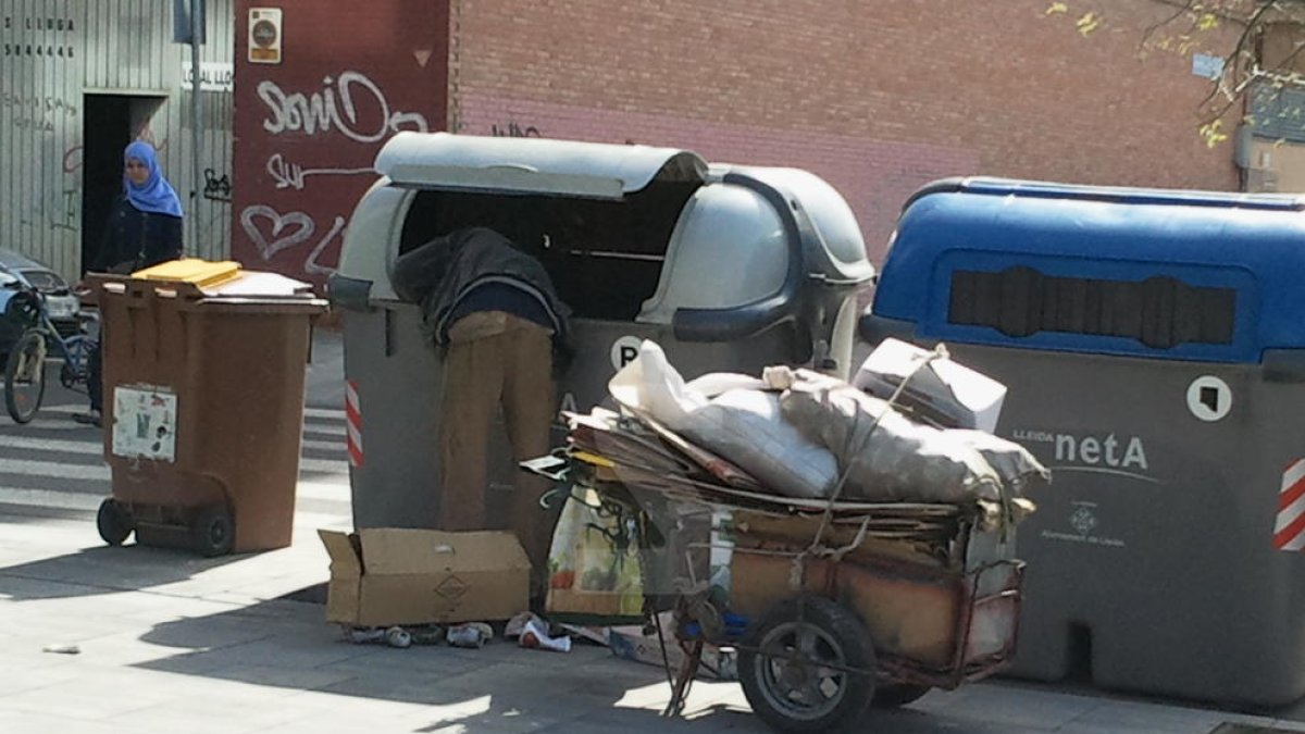 Un home buscant en un contenidor a Lleida.