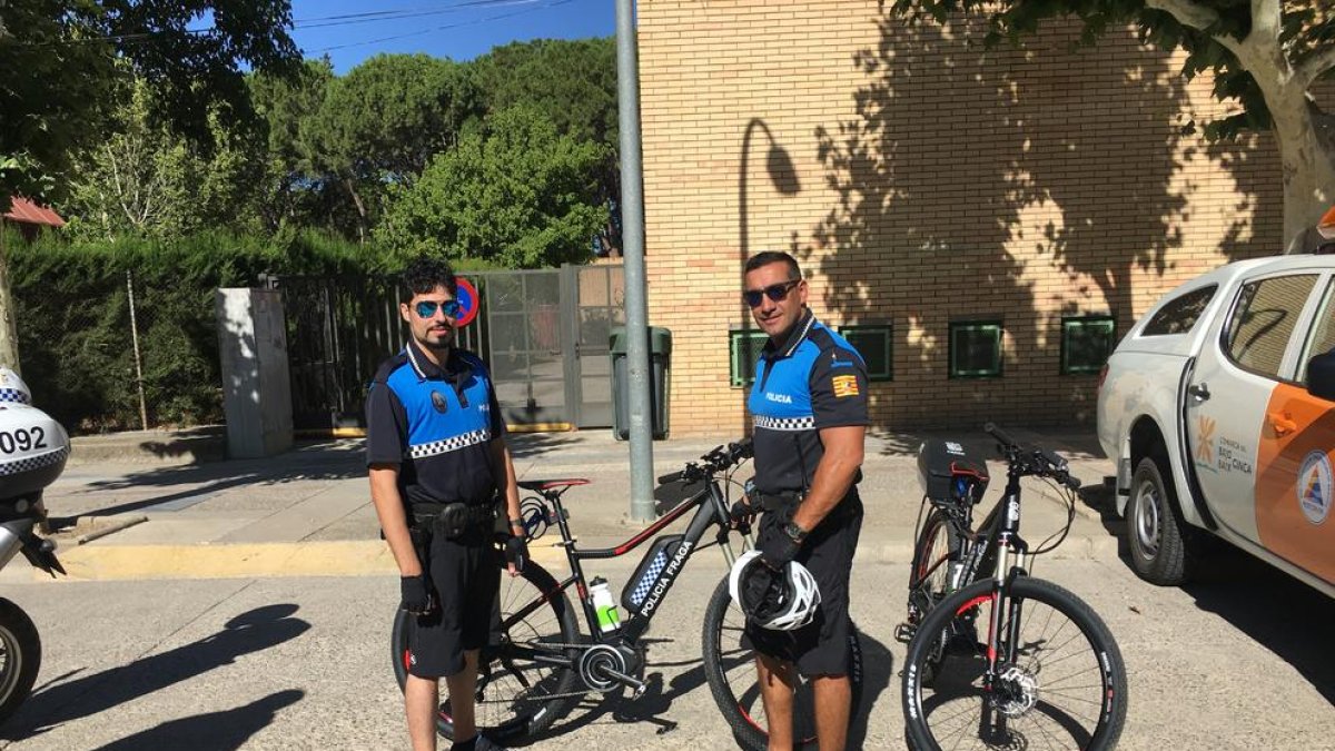 Dos miembros del cuerpo de la policía local de Fraga con las bicicletas eléctricas.