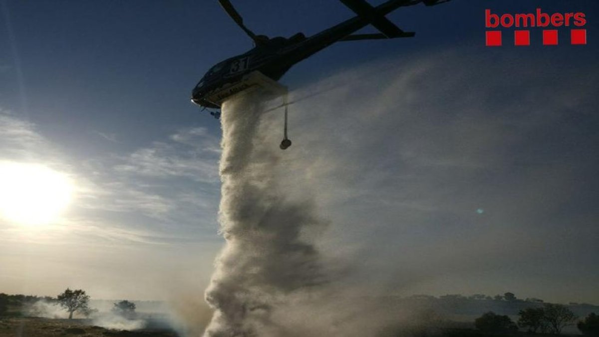 Un helicòpter, ahir, durant l’extinció del foc a les Garrigues.