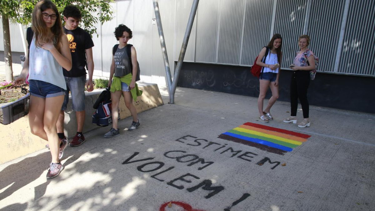 Alumnos miran una pintada en el instituto Gili i Gaya contra los comentarios homófobos de un docente. 
