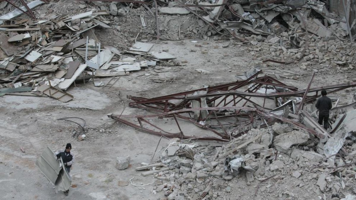 Persones busquen materials per poder vendre entre la runa de la demolició de l’antiga escola de Magisteri.