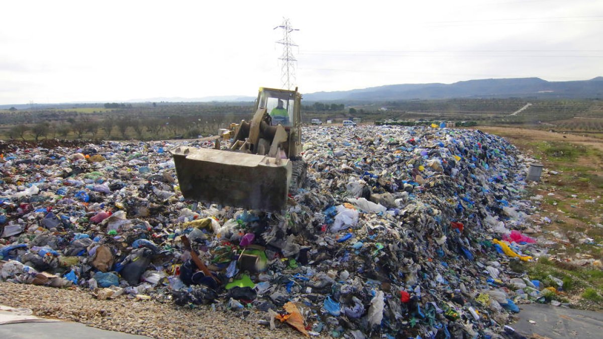 Una de las máquinas distribuyendo ayer la basura por el vaso del vertedero de Les Garrigues. 