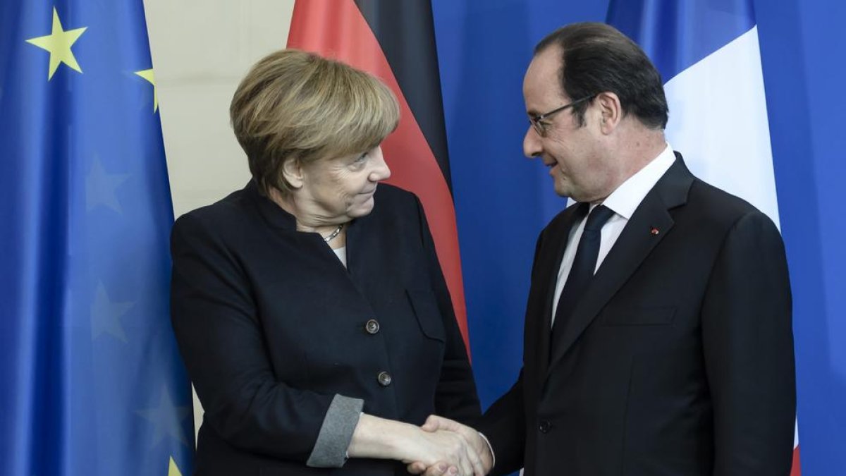 Merkel estreny la mà d’Hollande.