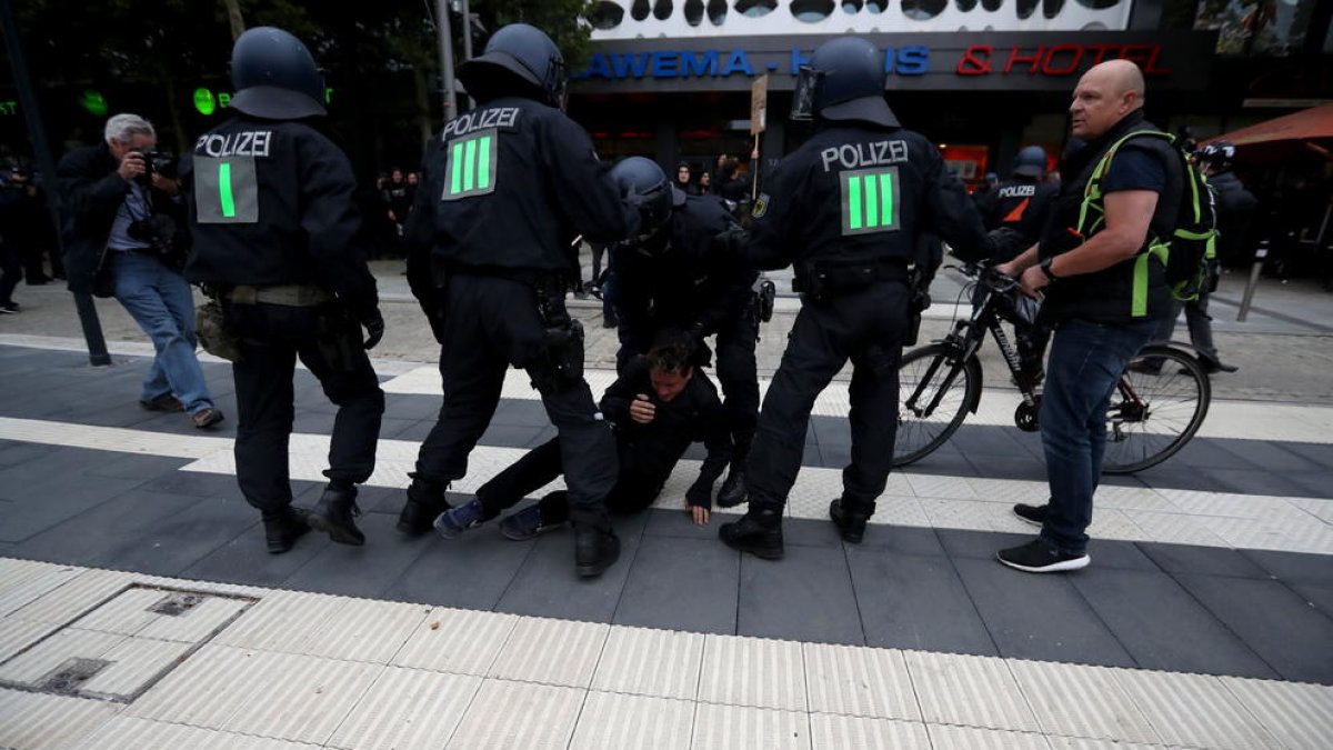 Policías reducen a una de las personas que participaron ayer en las marchas en la ciudad alemana de Chemnitz.