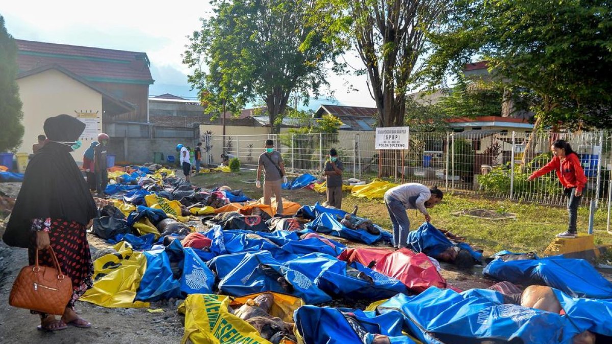 Varias personas buscan a sus familiares entre las víctimas ante una comisaría en Palu, Indonesia. 
