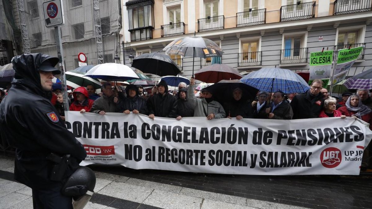 Pensionistes, concentrats ahir sota la pluja ahir a Madrid en defensa de prestacions dignes.