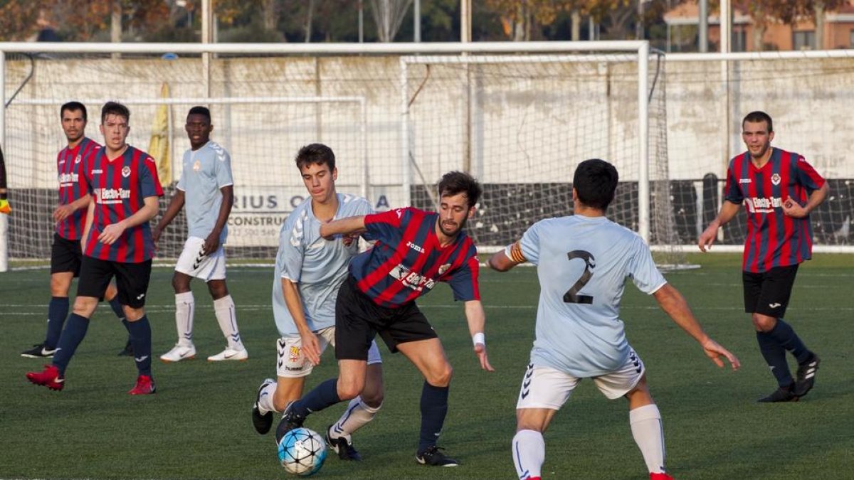 Un jugador del Tàrrega prova d’eludir la defensa de dos rivals.